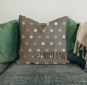 Detail view of Hello Fall linen pillowcase with maple leaf and polka dots on grey sofa