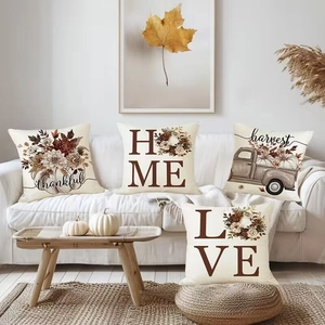 Detail of four fall harvest pillow covers featuring pumpkins and trucks on a sofa