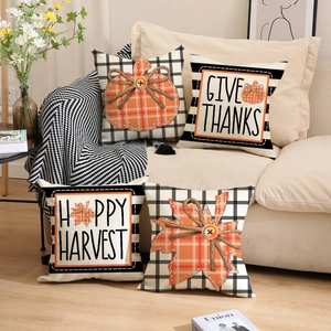 Detail of four Thanksgiving pillow covers with pumpkin patterns and harvest greetings