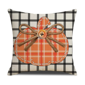 Detail of harvest pumpkin applique with jute bow on checkered cotton linen pillow cover