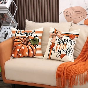 Detailed view of fall harvest pumpkin and maple leaf throw pillow covers on a cozy sofa