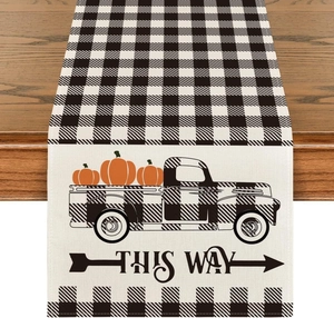 Detail of linen table runner with buffalo plaid, vintage truck, and orange pumpkins