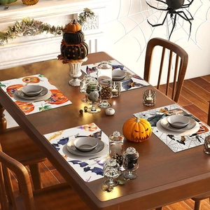Halloween placemats set with cartoon pumpkin and spider web designs on wooden table