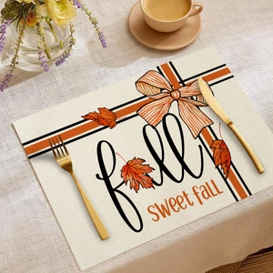 Dettaglio di tovaglietta in lino autunnale con foglie di acero e scritte decorative