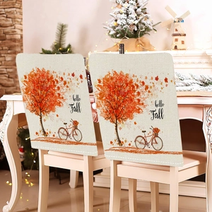 Detailed view of autumn pumpkin and maple leaf patterns on rustic linen chair covers