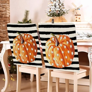 Détail de deux housses de chaise imprimé citrouille sur chaises dans un salon d'automne