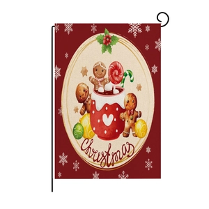 Detail of Christmas garden flag with gingerbread man and cocoa on red burlap texture