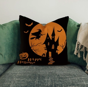 Detail of Halloween pillow with orange moon, witch, and castle silhouette on grey sofa