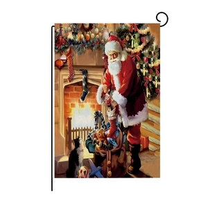 Detailed Christmas garden flag showing Santa by a fireplace on a black metal stand