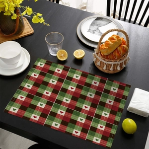 Detailed top view of a red and green plaid placemat with small heart patterns on a table