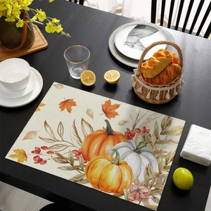 Close-up of harvest pumpkins and maple leaves printed on linen texture placemat