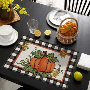 Detail of harvest pumpkin place mat with black gingham border and linen texture