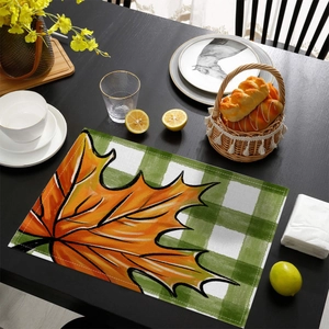 Detailed view of autumn pumpkin placemat fabric with maple leaf pattern and fine stitching