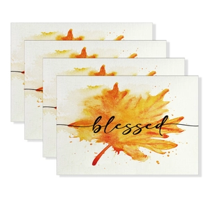 Set of 4 autumn placemats with orange maple leaves and blessed text on linen fabric