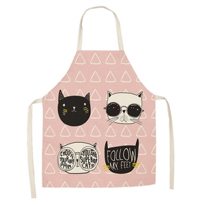 Detailed view of pink linen apron featuring cartoon cat prints and geometric patterns