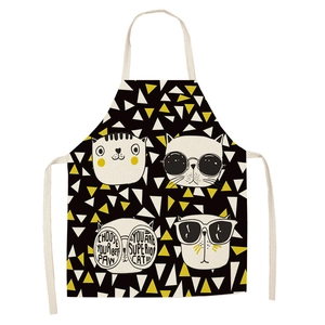 Close-up of linen apron featuring modern cat illustrations and geometric triangle patterns