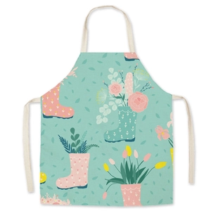 Detail of light green cartoon gardening apron with tulip and rain boot floral prints