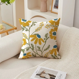 Detail of embossed cream fabric cushion cover with yellow floral pattern on a sofa