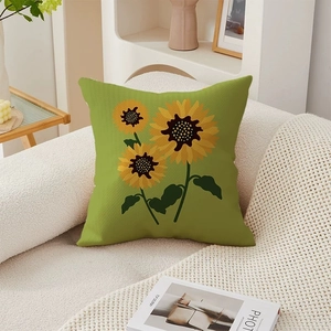 Green throw pillow cover with yellow sunflower print on a cozy white plush sofa
