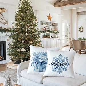 Close-up of blue snowflake and Let It Snow holiday cushion covers on a sofa