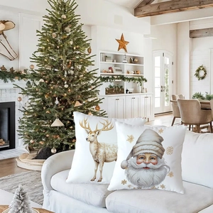 Christmas pillow covers with Santa and reindeer prints on a white sofa setting