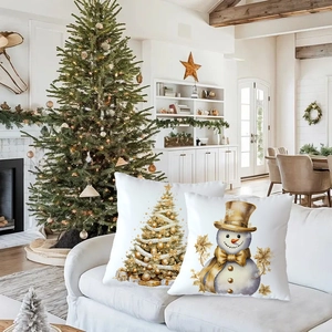 Detail of Christmas pillow covers with gold tree and snowman on a sofa in cozy living room