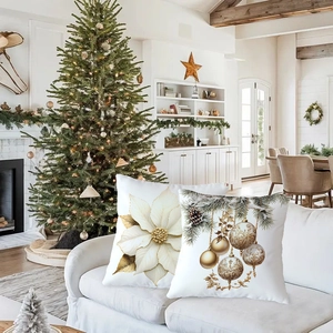 Detail of Christmas pillow covers with white floral and festive gold pinecone patterns