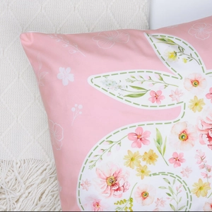 Close-up of pink Easter pillow case showing floral bunny pattern and white piping detail
