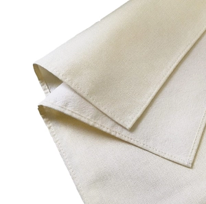 Detail shot of cream cotton linen table runner showing coarse grain texture and neat stitching