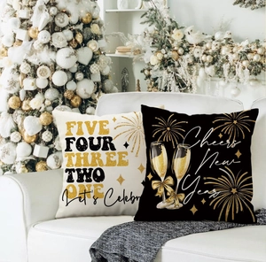 Detail of linen New Year pillowcases with fireworks and champagne theme on white sofa