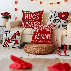 Detail view of four Valentine pillow covers with red hearts and festive typography text