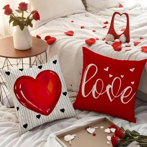 Detailed close-up of heart and love themed pillow covers on a bed with rose petals