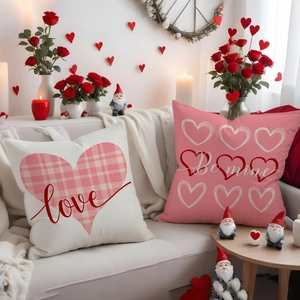 Close-up of Valentine pillow covers featuring Love and Be mine prints on a white sofa