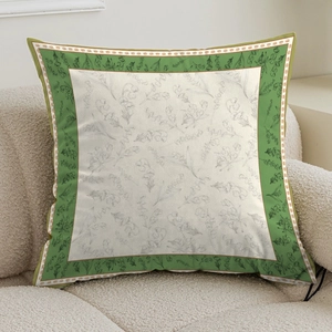 Detailed close-up of cream square pillow with green floral pattern on a boucle sofa