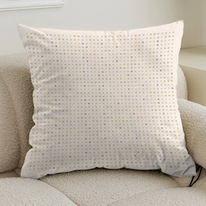 Detailed close-up of cream throw pillow cover with colorful dots on a soft sofa