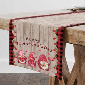 Valentine's Day gnome table runner with red plaid border on a light wood dining table
