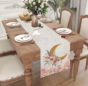 Dettaglio del runner da tavola bohémien con motivi di luna e fiori su tavolo di legno