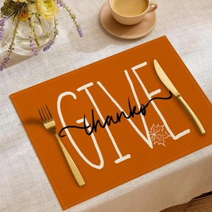 Orange linen Thanksgiving placemat with Give Thanks text and autumn maple leaf print