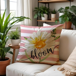 Linen decorative throw pillow with daisy bloom print and pink stripes on a white sofa