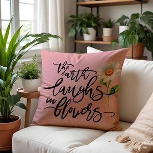 Linen throw pillow with the earth laughs in flowers quote and daisy print for sofa