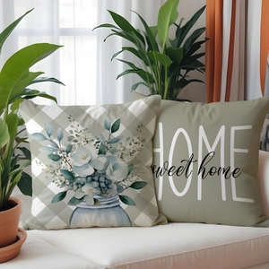 Detail of floral and home quote print on linen texture pillow covers on a white sofa