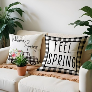 Detail of linen cushion covers with Welcome Spring floral truck and plaid border on sofa