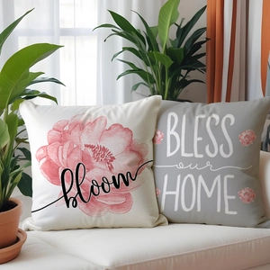 Détail de housses de coussin en lin avec fleurs et texte sur un canapé blanc