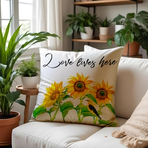 Linen sunflower pillow cover with Love lives here text on a modern white leather sofa