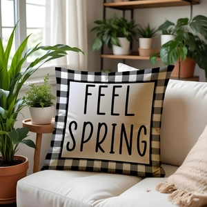 Feel Spring linen throw pillow with black and white plaid border on a white sofa