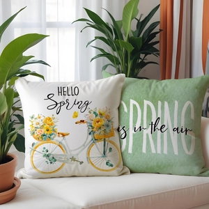 Detail of floral spring linen cushion covers with bicycle print on a white sofa