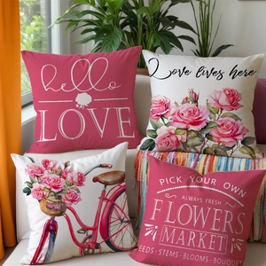 Detail of four floral linen pillowcases with rose and bicycle prints on a cozy beige sofa