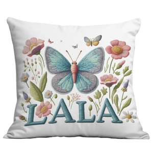 Detail view of floral embroidery with blue butterfly and pink flowers on white pillowcase