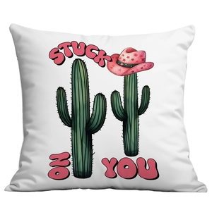 Close-up of white cushion featuring cactus with pink cowboy hat and Stuck On You text