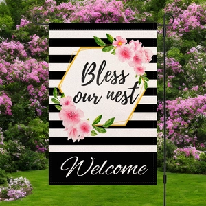 Garden flag with stripes and pink flowers including black metal stand on lawn